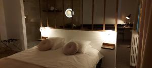 a bedroom with a white bed with two pillows at auberge le petit mas in Issoire