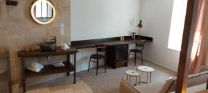 a bathroom with a sink and a counter with stools at auberge le petit mas in Issoire