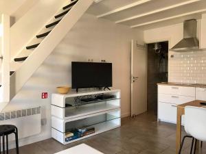 ein Wohnzimmer mit einem TV auf einer weißen Kommode in der Unterkunft Melroce Holiday Cottage 5504 in Bredene