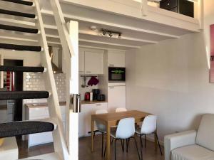 ein kleines Apartment mit einem Esstisch und einer Treppe in der Unterkunft Melroce Holiday Cottage 5504 in Bredene