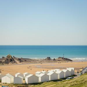 una spiaggia con edifici bianchi e l'oceano di The Edgcumbe Hotel & DECK Restaurant a Bude