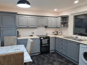 a kitchen with white cabinets and a sink and a table at No 14 in Wick