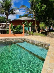 een zwembad voor een huis met palmbomen bij Solar corcovado in Ubatuba