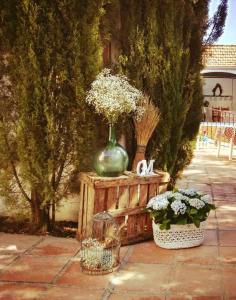 eine grüne Vase auf einem Holztisch mit Blumen in der Unterkunft Alojamiento El Cortijuelo in Escóznar