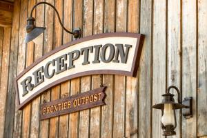 a sign on a wooden wall with a sign forigerhibition at Disney Davy Crockett Ranch in Villeneuve-le-Comte