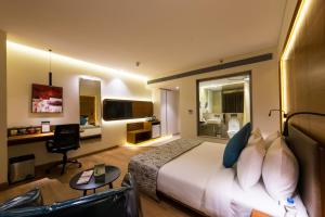 贾姆讷格尔The Fern Residency, Jamnagar的配有床和书桌的酒店房间