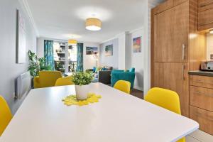 a kitchen with a white table and yellow chairs at Central Garden View -By My Getaways in Brighton & Hove