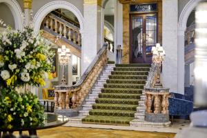a set of stairs in a building with flowers at The Clermont London, Victoria in London