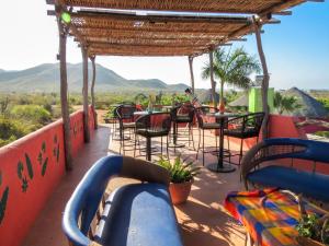a patio with tables and chairs and mountains in the background at Casitas El Salitral by Rotamundos in El Pescadero