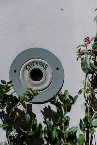 Ein Schild, auf dem die Hausaufgaben an einer Wand neben einer Pflanze stehen. in der Unterkunft Casa Barbabuc in Novello