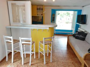 a kitchen and living room with a counter and chairs at Cavo Beach 3 in Cavo