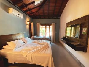 a bedroom with a large bed and a television in it at Pousada Arraial Charme in Arraial d'Ajuda +74 photos