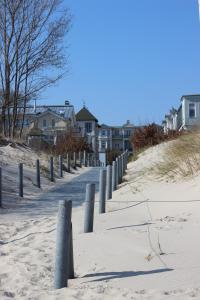 a row of posts in the sand on a beach at Villa Pippingsburg am Strand in Ahlbeck