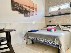 a bedroom with a bed with pink pillows on it at Bruno´s House Apartment View in Pájara +12 photos