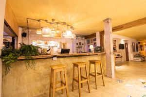 a kitchen with a bar with three stools at Hotel Barahona Cartagena in Cartagena de Indias