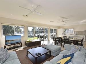 a living room with a couch and a table at Wangi Lakehouse in Wangi Wangi