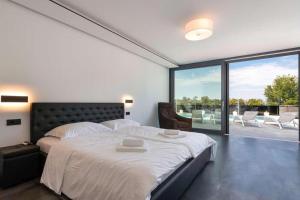 a bedroom with a large bed and a large window at Seaview in Funtana