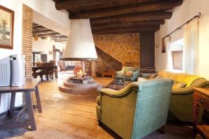 - un salon avec un canapé et une cheminée dans l'établissement Alojamiento El Cortijuelo, à Escóznar