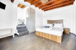 a bedroom with a bed with white sheets and wooden ceilings at Belvedere in Livadi