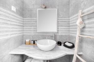 a bathroom with a white bowl sink on a counter at Belvedere in Livadi