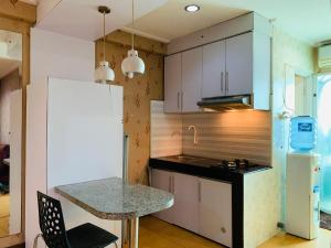 a kitchen with a counter and a white refrigerator at Apartemen Cibubur Village by Raja Sulaiman Property in Cibubur