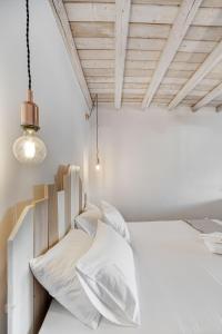 a bedroom with a white bed with white pillows at Belvedere in Livadi