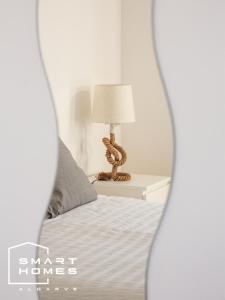 a bedroom with a bed and a lamp on a table at Villa Ancora modern One bed apartament in Lagos Marina in Lagos