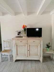 una TV in cima a un mobile in legno in una stanza di La Bella Vite a Moncalvo