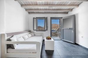 a white living room with a couch and a table at Belvedere in Livadi