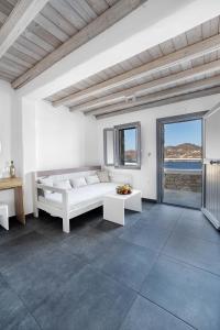 a white room with a bed and a view of the ocean at Belvedere in Livadi