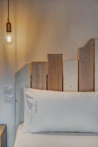 a bed with a wooden headboard and a white pillow at Belvedere in Livadi