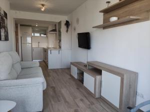 salon z kanapą i telewizorem oraz kuchnia w obiekcie MALAGUEÑA VIEWS w mieście Torremolinos
