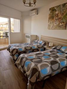 sypialnia z dwoma łóżkami i oknem w obiekcie MALAGUEÑA VIEWS w mieście Torremolinos