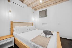 a bedroom with a white bed with a towel on it at Belvedere in Livadi