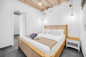a bedroom with a large bed with a wooden headboard at Belvedere in Livadi