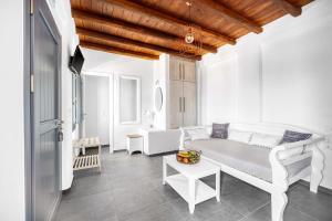 a white living room with a couch and a table at Belvedere in Livadi