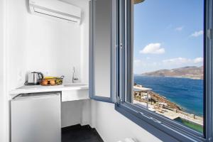 a kitchen with a window with a view of the ocean at Belvedere in Livadi