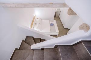 a staircase in a house with white walls and wooden ceilings at Belvedere in Livadi