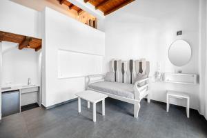 a white living room with a chair and a table at Belvedere in Livadi