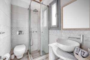 a bathroom with a shower and a sink and a toilet at Belvedere in Livadi
