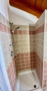 y baño alicatado con ducha y bañera. en CasaDina Apartment IUN Q2891, en Oschiri