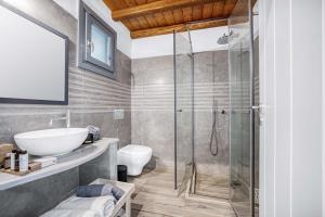 a bathroom with a shower and a sink and a toilet at Belvedere in Livadi