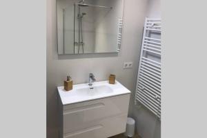 W łazience znajduje się biała umywalka i lustro. w obiekcie Estudio reformado con parking en Vall d'Incles, Grandvalira w mieście Canillo