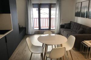 uma sala de estar com uma mesa e cadeiras e um sofá em Estudio reformado con parking en Vall d'Incles, Grandvalira em Canillo mais 14 fotografias