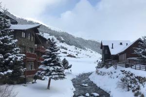 um alojamento de esqui com neve no chão e árvores em Estudio reformado con parking en Vall d'Incles, Grandvalira em Canillo