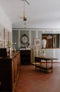 a living room with a clock on the wall and a table at Casa Barbabuc in Novello