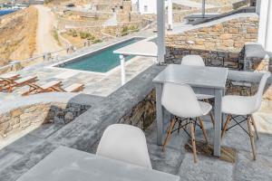 a table and chairs on a patio with a pool at Belvedere in Livadi