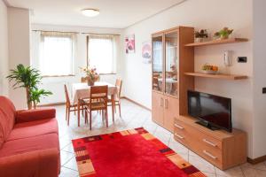 a living room with a couch and a tv and a table at Casa al Moro in Rocca Pietore