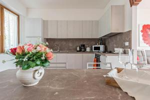 a kitchen with a vase with flowers on a table at Bel Soggiorno lake view 1 in Tremosine Sul Garda +22 photos