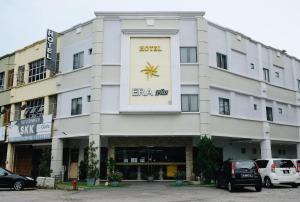 un gran edificio blanco con un cartel. en Era Plus Hotel, en Seri Kembangan